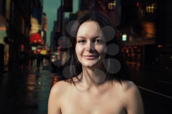 Shirtless brunette smiling in the night street. Outdoors shot
