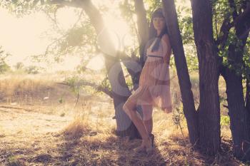 Backlit shot of a pretty women near trees in summer