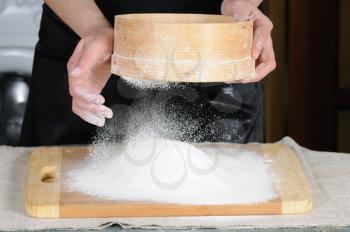 Royalty Free Photo of a Person Sifting Flour Through a Sieve