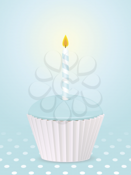 Cupcake with blue icing and birthday candle on a blue polka dot background