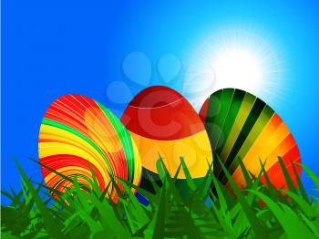 Colourful striped Easter eggs on Green Grass Over Blue Sunny Sky Landscape Background