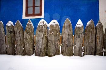 Royalty Free Photo of a Snowy Fence by a House