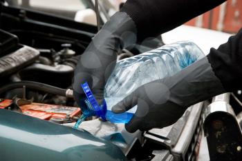 Royalty Free Photo of a Mechanic Filling a Car With Washing Liquid
