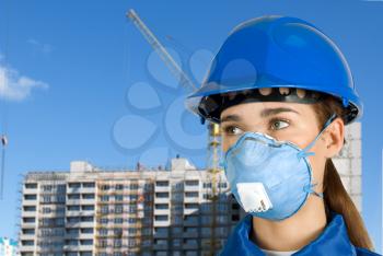 Royalty Free Photo of a Female Builder Wearing a Mask and Hardhat