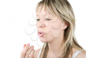 Royalty Free Photo of a Woman Putting on Lip Gloss