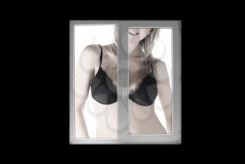 Royalty Free Photo of a Woman Standing in a Bra in Front of a Window