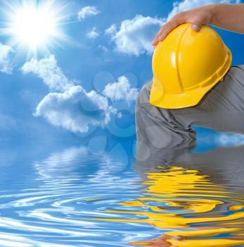 Royalty Free Photo of a Builder Holding a Hardhat in Water