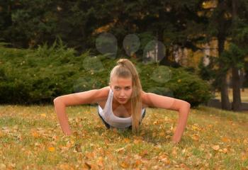 Royalty Free Photo of a Woman Doing Push-Ups in a Park
