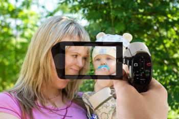 Royalty Free Photo of a Mother and Baby Being Filmed