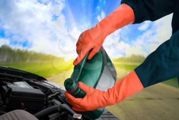 Royalty Free Photo of a Man Pouring Motor Oil into the Engine