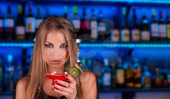 Girl with cocktail on bar counter background