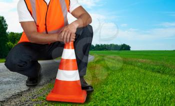 road worker closeup with orange posts at road