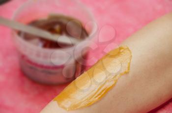 Sugaring: epilation with liquate sugar at legs. It is less painful hair removal with wax replacement