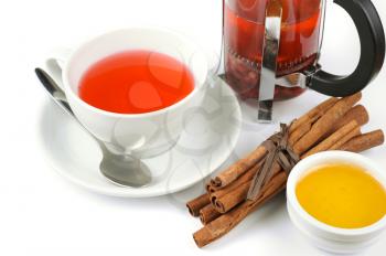 Cup of hot berries tea with cinnamon sticks, and honey