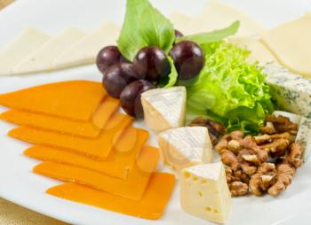 cheese with lettuce, grapes and nuts closeup