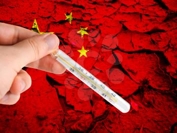 Hand with a medical thermometer on China flag backgound. Concept of corona virus.