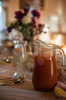 Decorated table with jug of juice on foreground