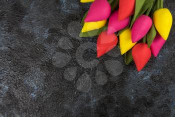 Handmade tulips on darken concrete background for Mother's Day, spring time or Easter theme.