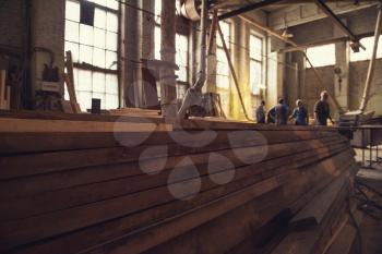 Stack of wooden blanks at the sawmill. Workers on background.