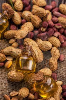 Natural peanuts with oil in a glass jar on the wooden background