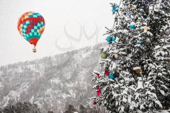 New year fir tree in the mountain forest and aerostat in the sky