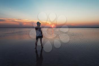Man walking on salty lake at beauty sunset in Altay, Siberia, Russia