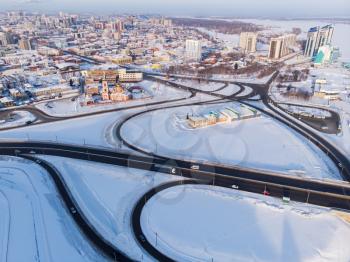 Aerial shot of road and cars driving on the road, winter sunny day in Barnaul, Siberia, Russia