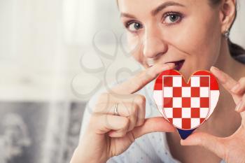 Young woman with gingerbread heart cookies with flag of Croatia