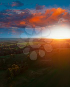 Top aerial view of green fields and meadows in evening summer with beauty sunset sky