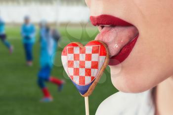 Closeup photo of the woman lips and cookie hearts with flag of Croatia