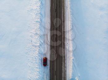 Aerial view of a road with car in winter landscape, top view