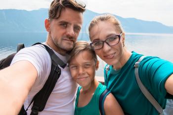 Selfie of family on the Teletskoye lake in Altai mountains, Siberia, Russia. Beauty summer day.