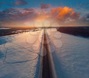 Aerial view of a road with sunset sky in winter landscape