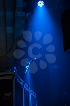 Concert stage: microphone in concert hall with blue lights