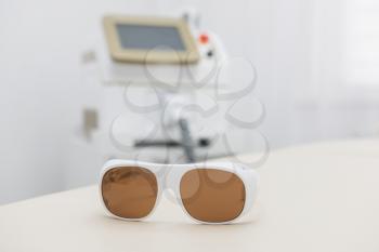 Protective glasses on laser epilation equipment in spa center. Hair removal cosmetology concept.