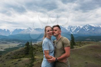 Romantic couple in the mountain, in Altai Mountains. Happy man and woman out of focus. Focus on the background