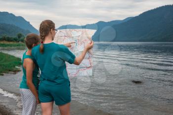 Woman and her son seeing the map on Teletskoye lake in Altai mountains, Siberia, Russia.