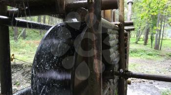 Rustic watermill with wheel being turned by force of falling water from Altai mountain river.