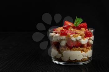 Strawberry with cookie and cream dessert decorated with mint leaf on black wooden background, with copyspace, food and drink concept
