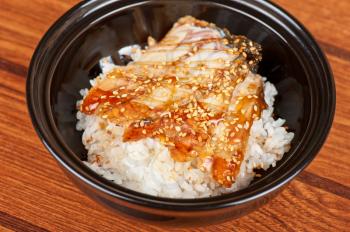 Japanese cuisine, eel with rice at black plate