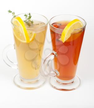 Two tea glasses with thyme lemon and briar on a white