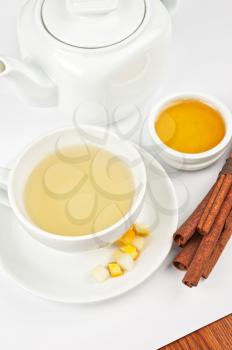 Cup of hot linden tea with cinnamon sticks, and honey