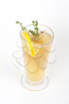 tea glass with thyme lemon on a white