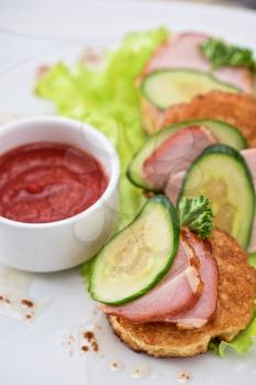 pancakes with ham and cucumber with tomato sauce and lettuce