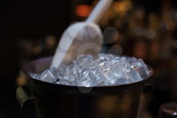 Ice bucket filled with ice cubes closeup