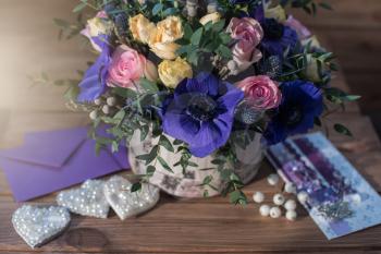 beautiful bouquet flowers and hearts at wooden background