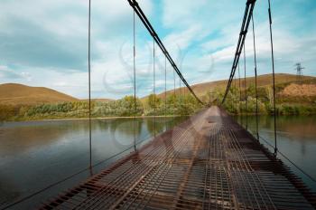 Suspension bridge at cloudy autumn day