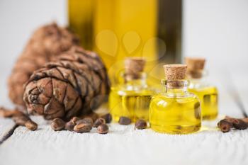 The cedar oil in a glass bottle on a white wooden background. Source of essential fatty acids for healthy nutrition