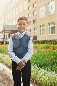 The first time in first class: happy schoolboy at school background