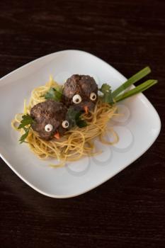 Funny meatballs with pasta greens and green onion for children menu